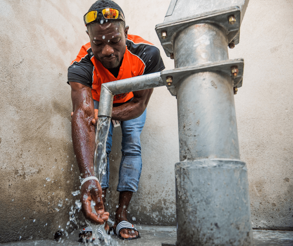 A Haitian man washes his hands from a clean-water pump on Global Handwash Day.