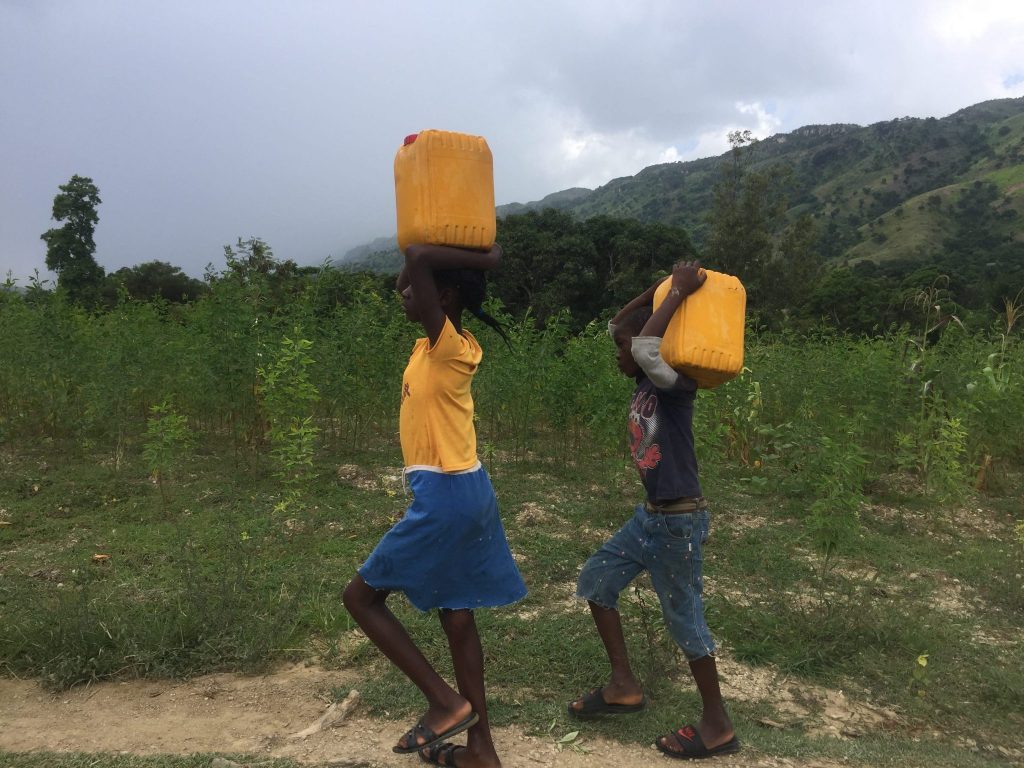 Fetching water is a daily task, often performed by children, in Haiti.