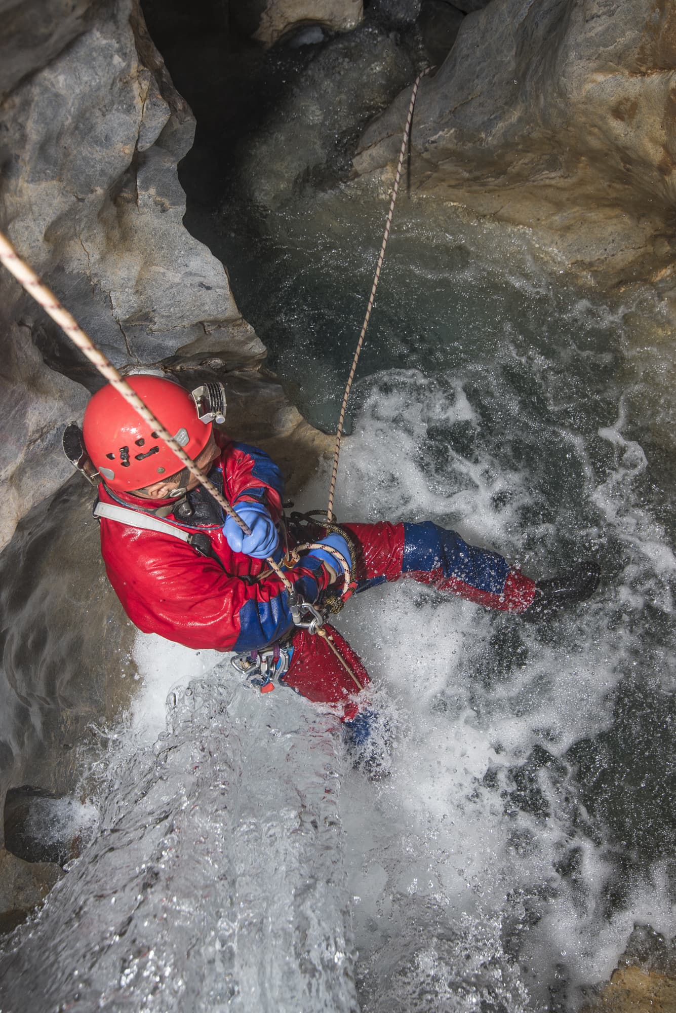 The travel to unexplored passages can sometimes take 12-30 hours and is arduous. In this photo, Andreas Klocker rappels through a waterfall in the San Agustín Gorge. (Photo by Chris Higgins)