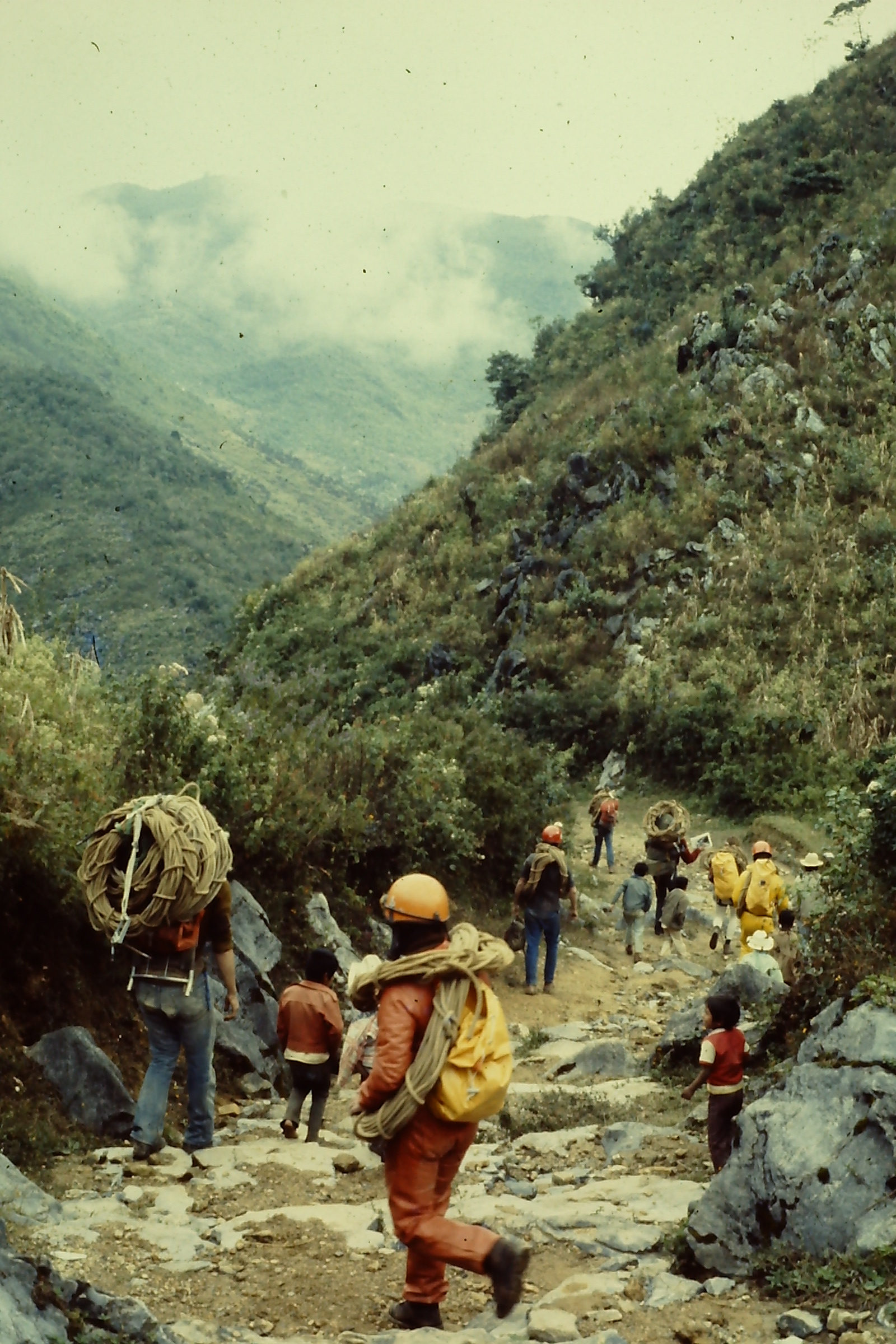 During the 1977 overland survey, cavers carry rope, packs, and other gear on their way to the cave. (Photo by Bob West, courtesy of PESH)