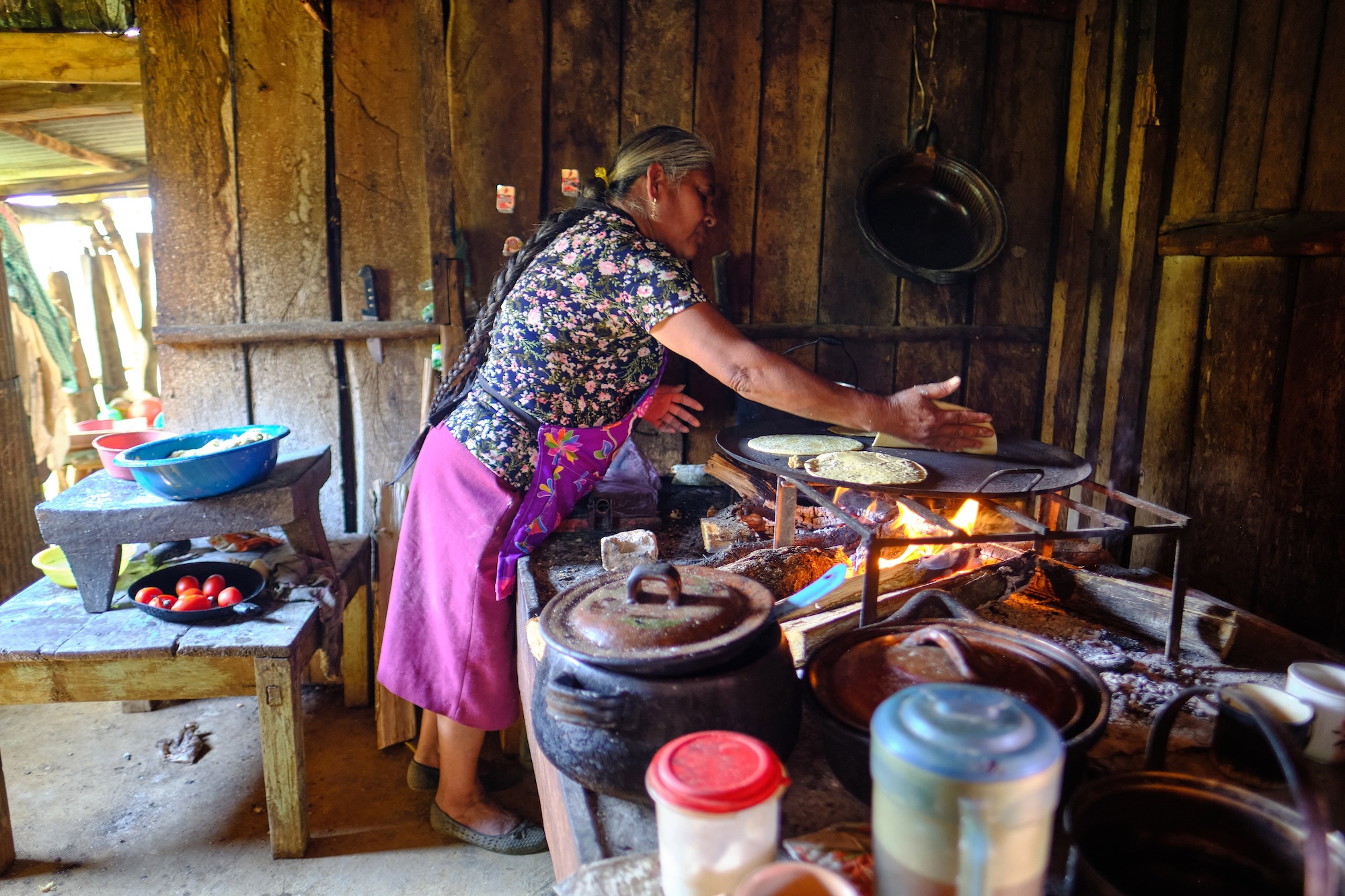 According to Shifflett, "This is a photo of Berta, a Mazatec lady who was a little girl back in the late 1970s and early 1980s who lived in the San Agustín community. She would later marry a Mazatec man and move to Plan de Escoba, the area we [PESH] are exploring to the north of Sistema Huautla. In early 2019, prior to the 2019 expedition, Berta identified Bill Steele as someone from her past, and she offered to rent PESH some of the buildings owned by her and her husband to use as a base camp. Otherwise, we had no access to this area. In the picture, Berta is preparing tortillas in the same way as done for centuries — hand made and best I have eaten." (Photo by Matt Tomlinson)