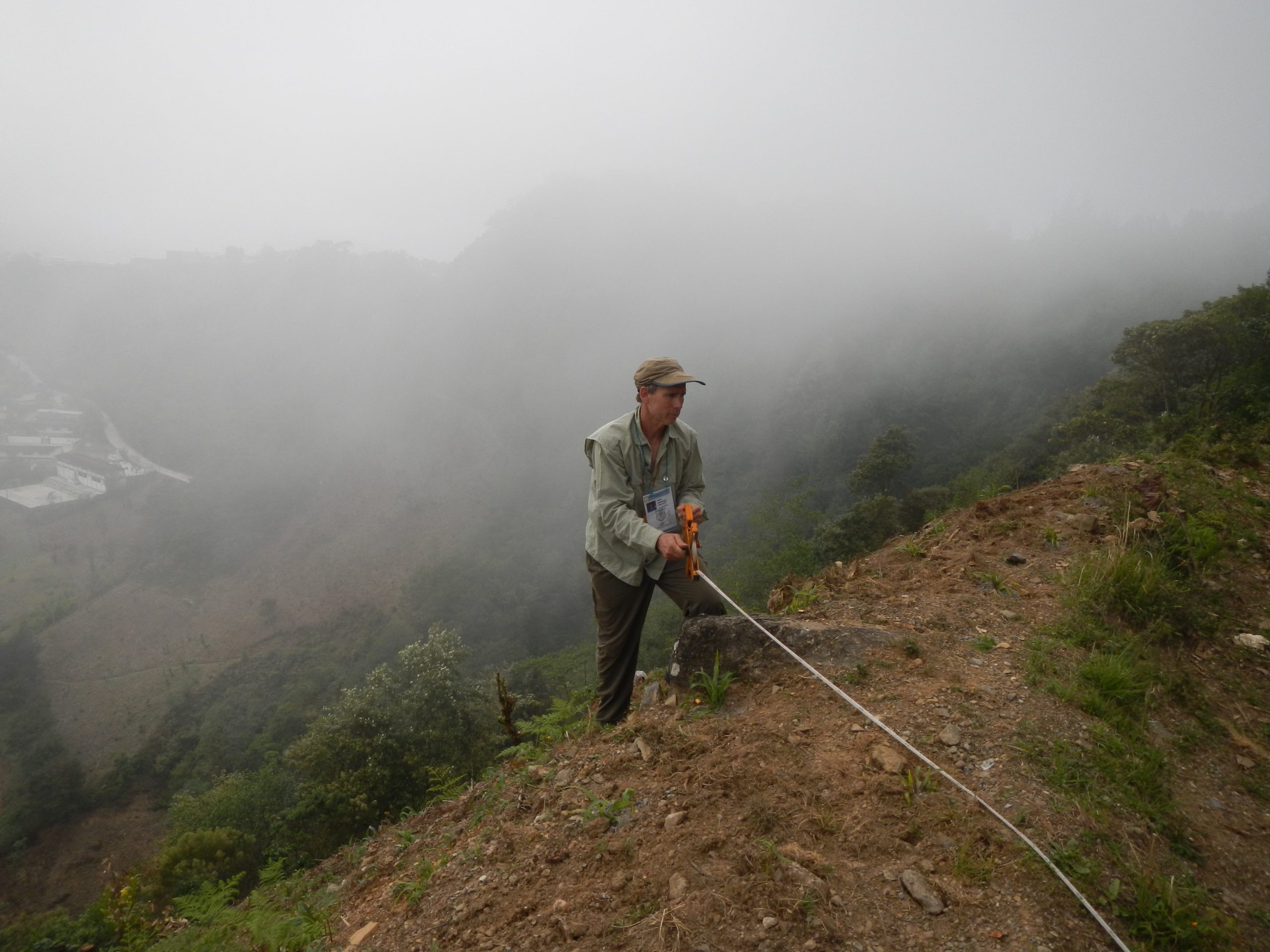 Proyecto Espeleológico Sistema Huautla (PESH) co-founder Thomas Shifflett uses tape to measure the distance of the survey shot for mapping of cave entrances