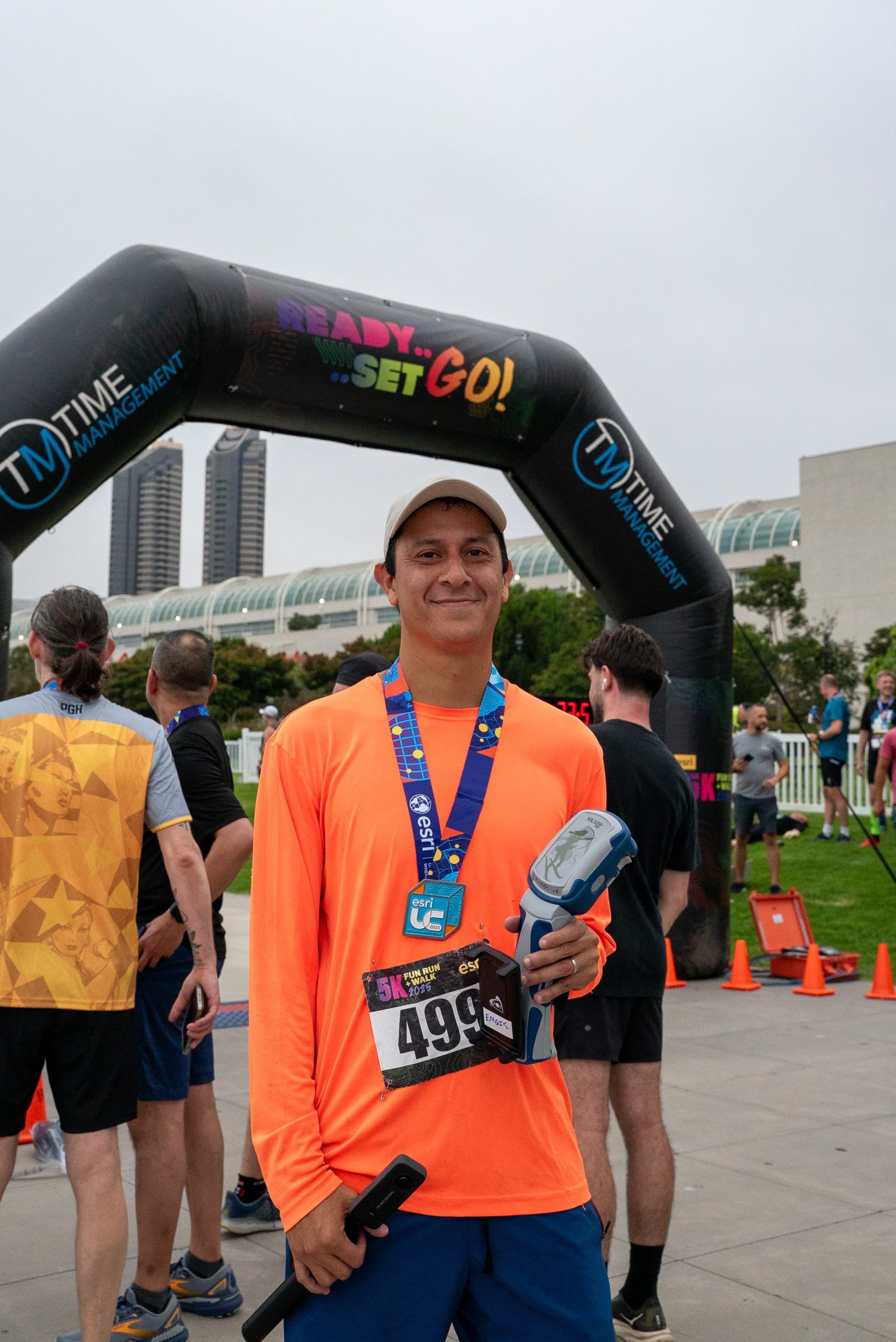 20 - Manny Lopez posing at 5K finish copy ASM Affiliates GIS Specialist Manny Lopez posed at the finish line with the Skadi GNSS receiver he used to map the race!